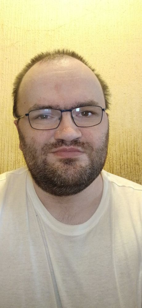 Me against a beige wall wearing a white tee shirt. 