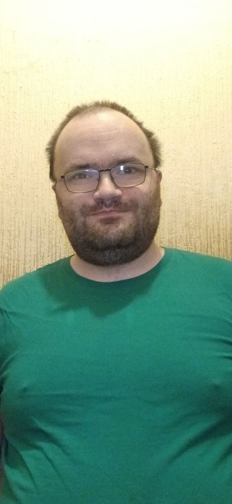 Me against a beige wall wearing a green tee shirt