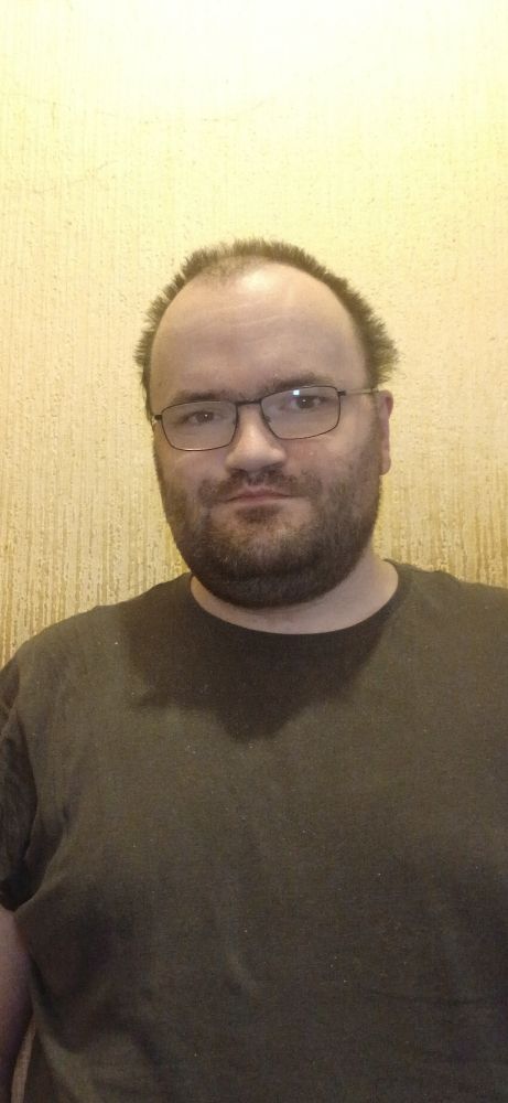 Me against a beige wall wearing a grey tee shirt 