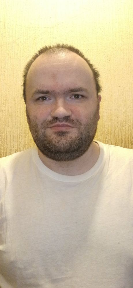 Me against a beige wall wearing a white tee shirt 
