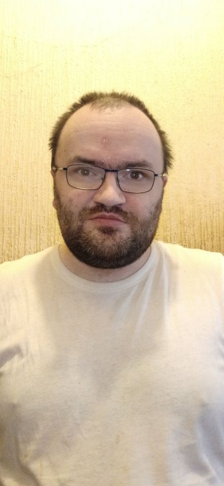 Me against a beige wall wearing a white tee shirt 