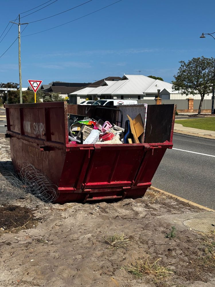 Nearly full 10 cubic metre skip bin, orange, verge side 