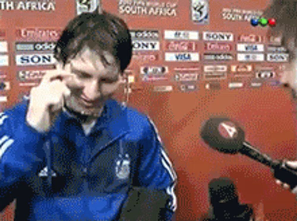 a man talking into a microphone in front of a wall that says south africa on it