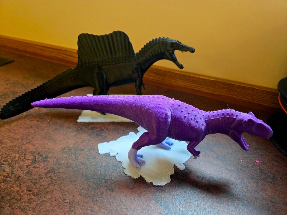 Two 3D-printed dinosaurs with lots of detail and realism. One is Spinosaurus and the other is an Allosaurus. 