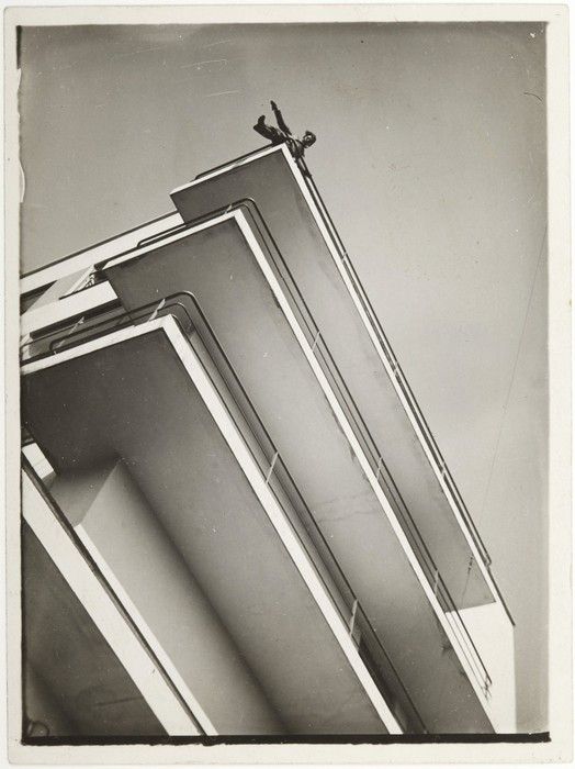 A black and white photograph of a Bauhuas building with a figure on the top floor by Moholy-Nagy