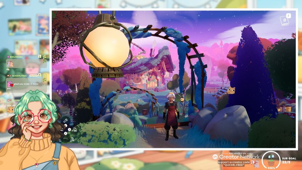 blurred pastel stream background with chat bubbles, captions, ea creator network logo and sub goal showing. the main features are my pngtuber smiling in the corner and the game shown which is wanderstop. it shows the main adventurer a tan woman with white hair wearing a red apron standing up the top of a set of stairs in front of a magical forest and tea shop with lots of shades of blue and purple.