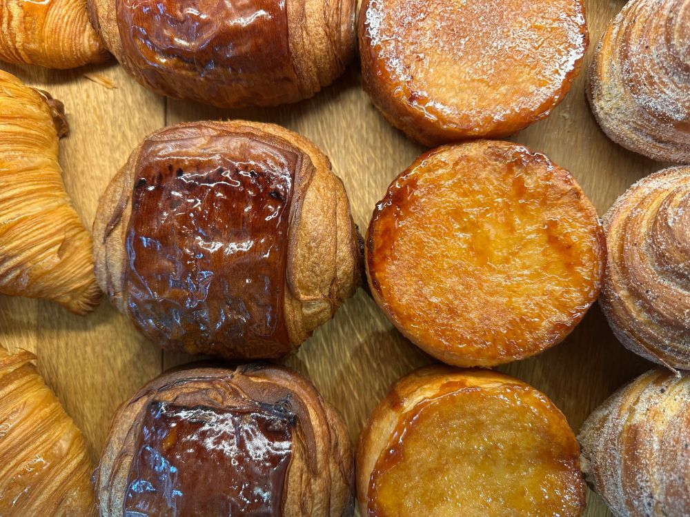 assortment of croissants and sticky buns shot from above 