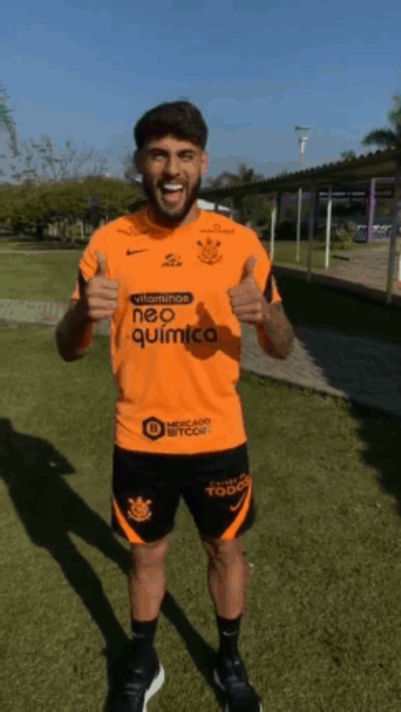 a man wearing an orange shirt that says vitaminos neo quimica is giving a thumbs up