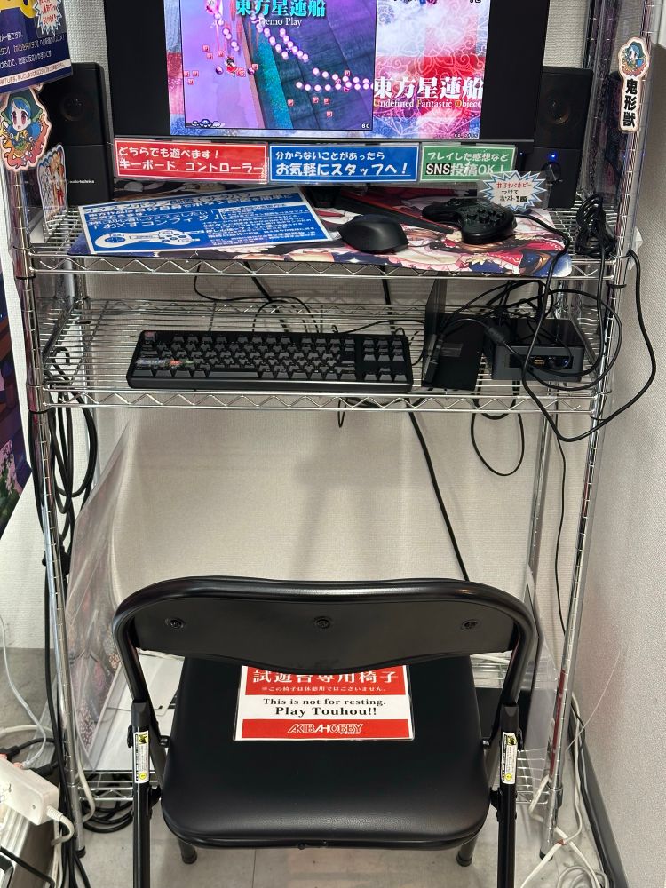 Station to play a Touhou game with a sign on the chair that says “This is not for resting, play Touhou!!!”