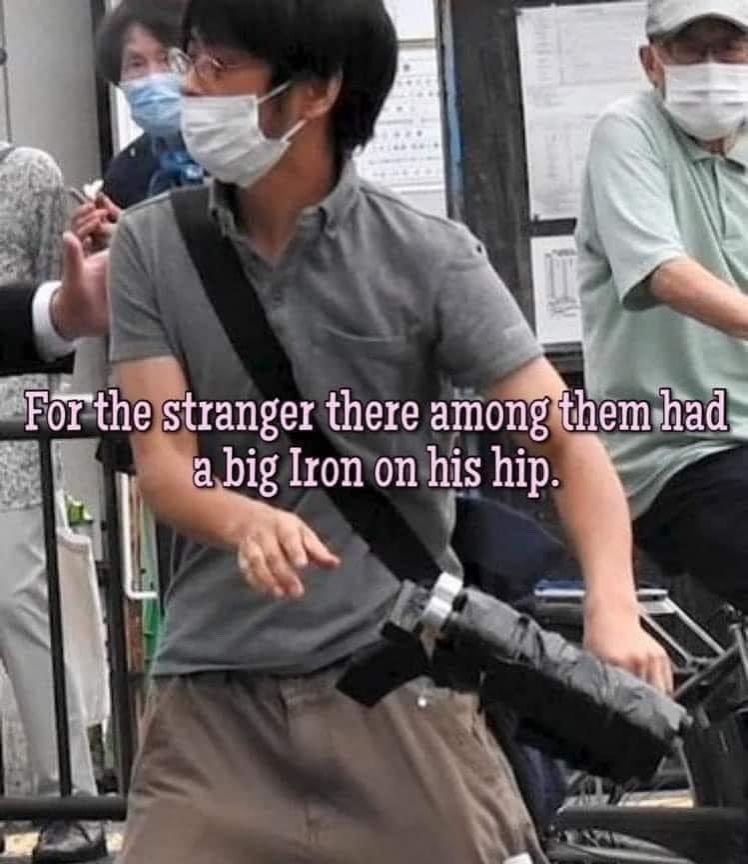 Photo from the assassination of Shinzo Abe, two years ago today. Doohickey is visible. Text reads "for the stranger there among them had a big Iron on his hip."