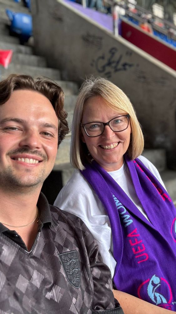A young man and his mum smiling