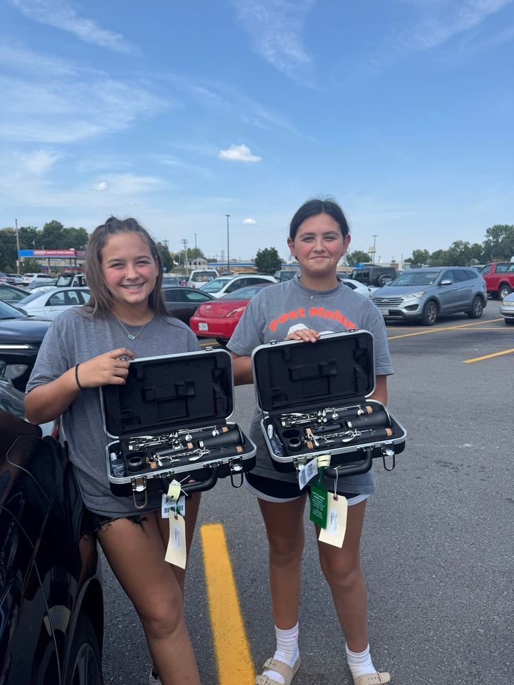 2 teenage girls each showing their new clarinets 