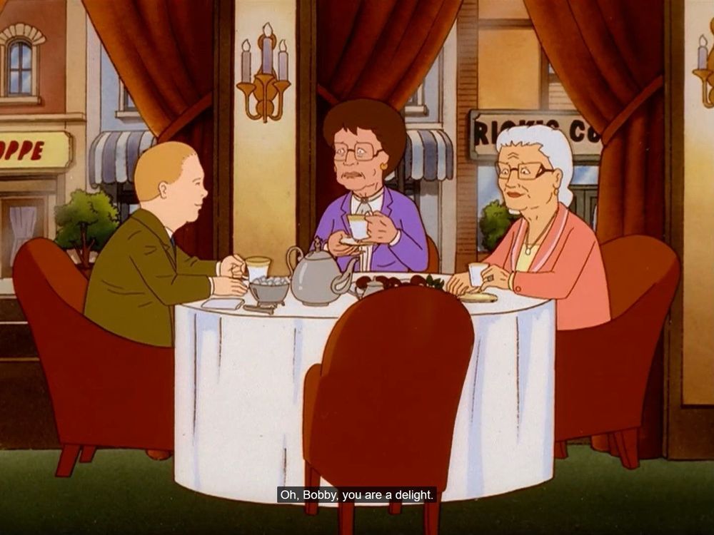 Bobby Hill in a brown suit having tea with two older women.  They say "Oh, Bobby, you are a delight".