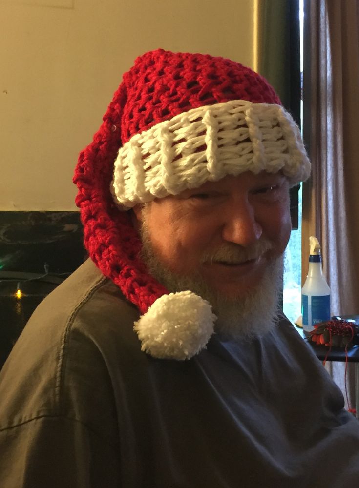My late husband John, a Santa in the flesh, wearing a handmade crocheted Santa hat. His blue eyes are even twinkling. 