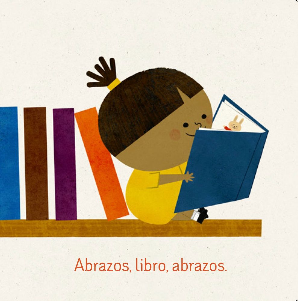 interior art from Abrazos for Baby showing a little girl sitting at the end of a row of books on a bookshelf, reading a book with a blue cover. The text reads: "Abrazos, libro, abrazos."