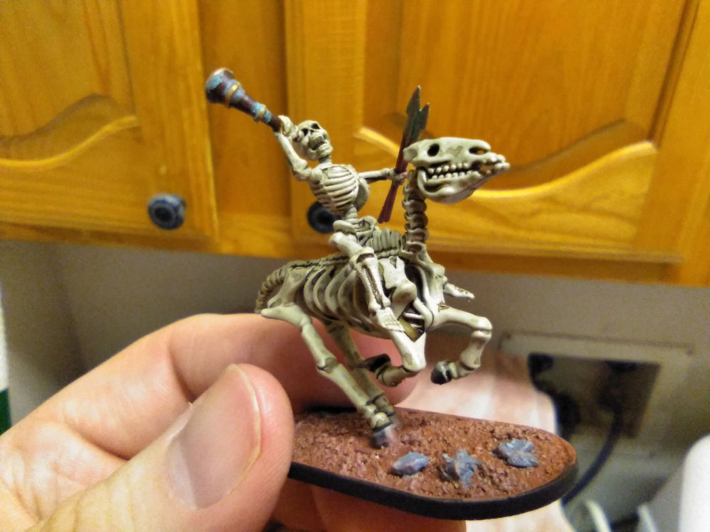 Miniature: Skeleton cavalry musician, leaning back to blare warhorn. Left hand carries two spare spears. Horse rearing back.