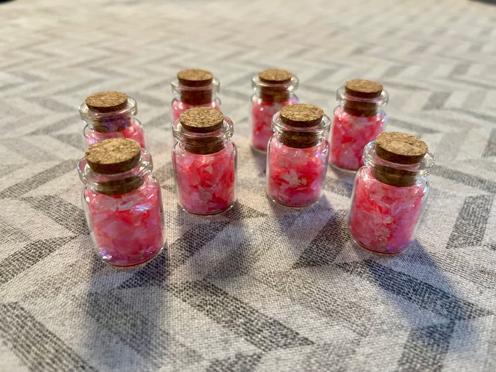 Small flasks with pink glitter representing healing potions