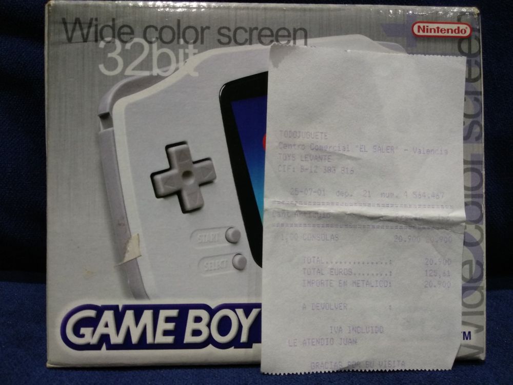No fundo, está a caixa original da minha Game Boy Advance Branca, e tem dentro a Game Boy Advance que funciona igual de bem que o primeiro dia, porque eu cuido bem das cousas. Diante da caixa está o ticket, que di:

TODOJUGUETE
Centro Comercial "El Saler" - Valencia
Toys Levante

25-07-01

Total: 20.900
Total euros: 125,61
Importe en metálico: 20.900

IVA incluido
Le atendió Juan
Gracias por su visita