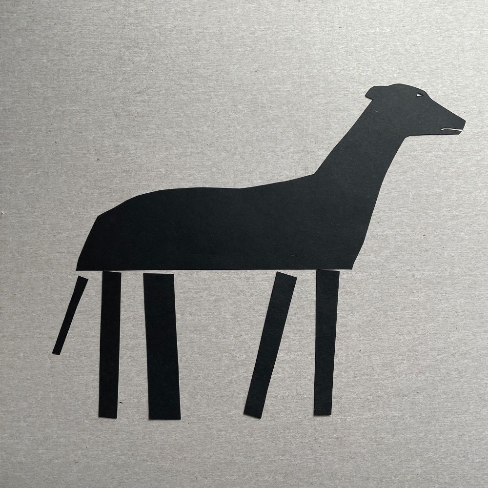 black paper cut of a dog, the top half is fairly representative but the legs are just stick legs. build back better.