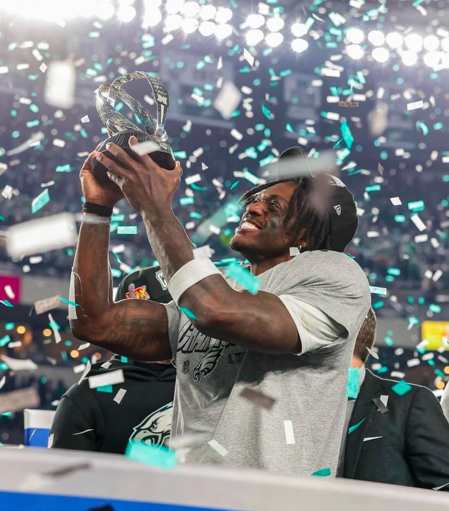 A.J. Brown holds the NFC trophy and smiles