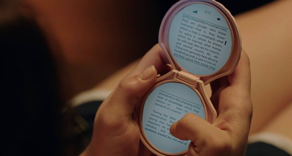 picture of hands holding a pink seashell e-reader from the movie it follows 