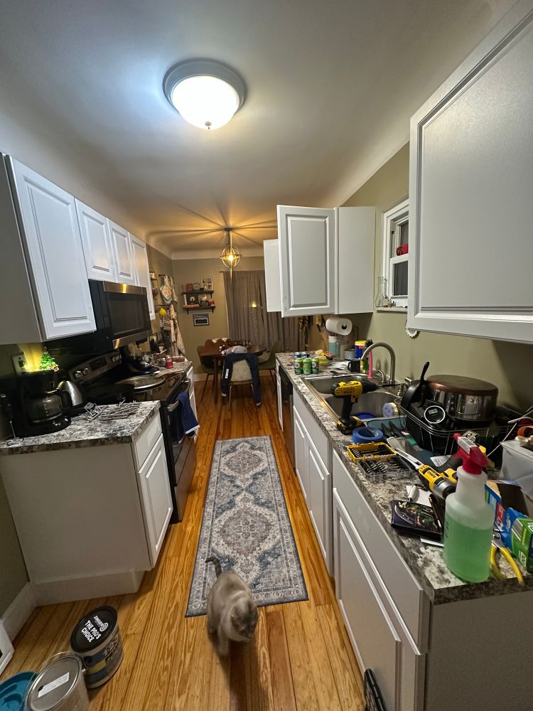 messy kitchen with white cabinets