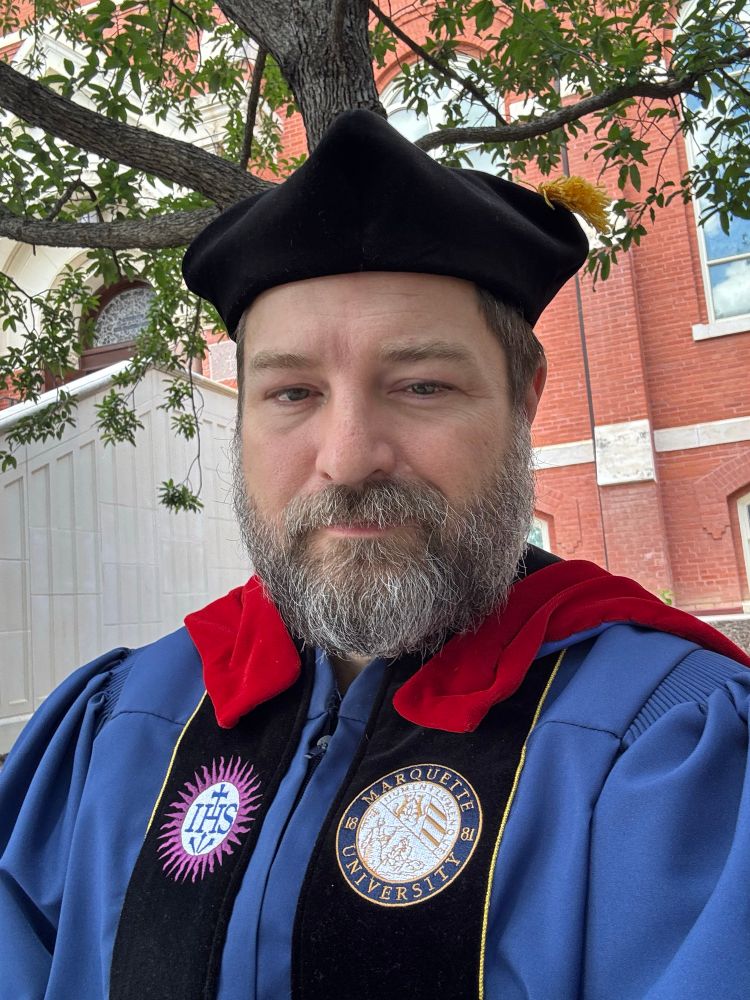 A rapidly aging professor in Marquette Doctoral robes