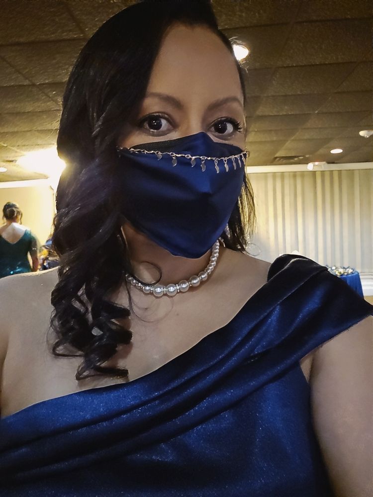 Author's in a navy blue satin one-shoulder dress with matching silk mask, gold mask chain, short pearl necklace and side-swept shoulder length curled hair. looking quite lovely, she might add.