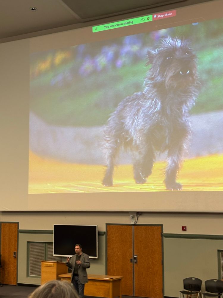 Lecture room with a large screen with a dog from Oz.