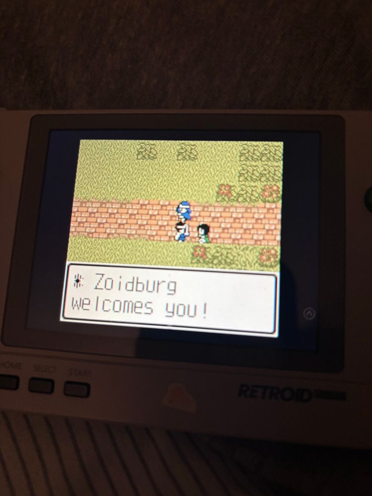 Photo of a Retroid emulating the GameBoy Color version of Dragon Quest III, the hero is talking to a resident.

The text reads “Zoidburg welcomes you!”