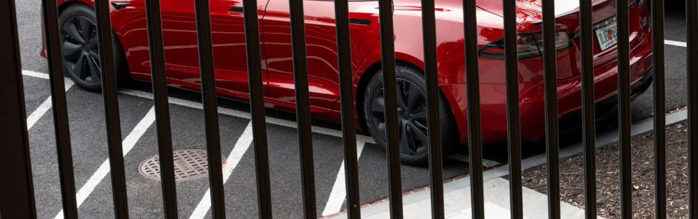 A red Tesla, parked outside the lines. 