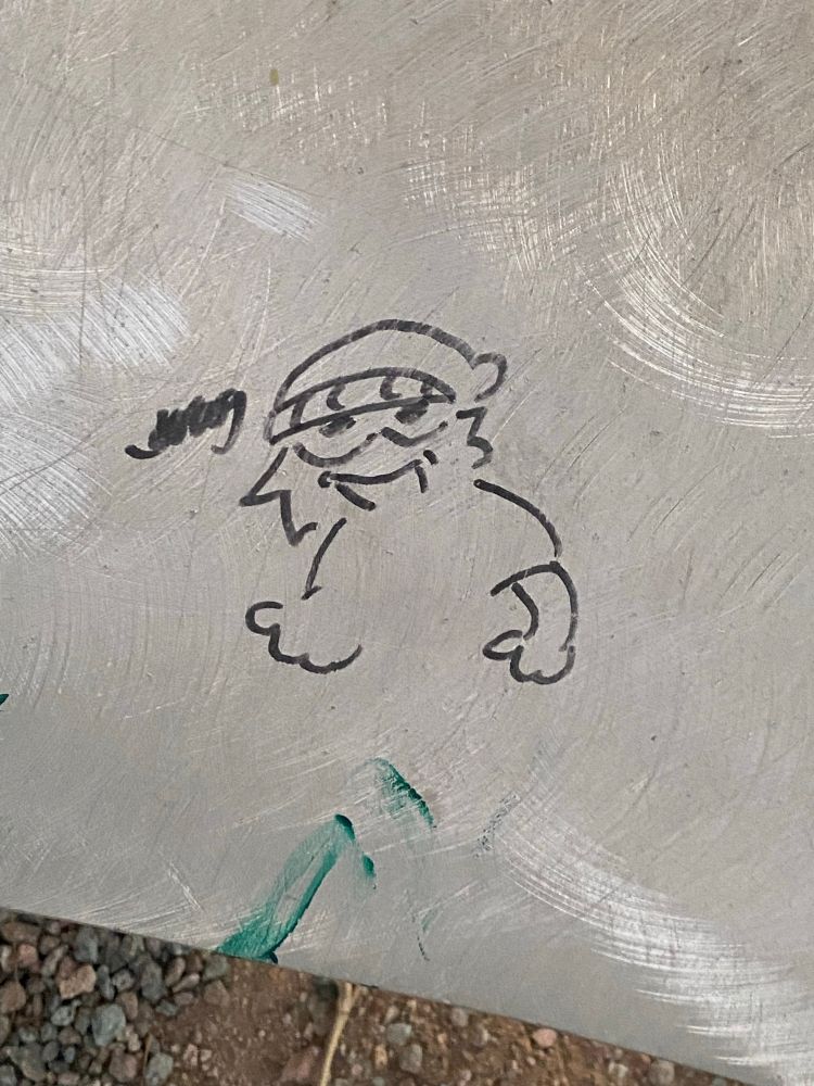 Graffiti of a yeti wearing a soft cap. 