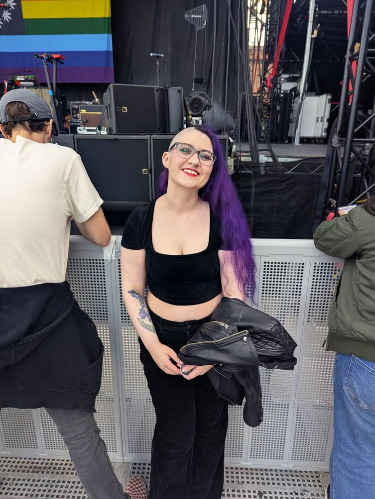 A second shot of Erika smiling in front of the stage barricade