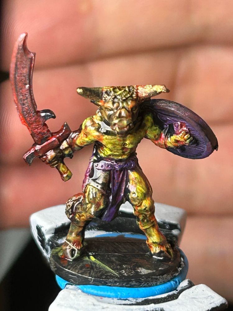 Yellow Minotaur miniature roughly painted and spattered purple and red