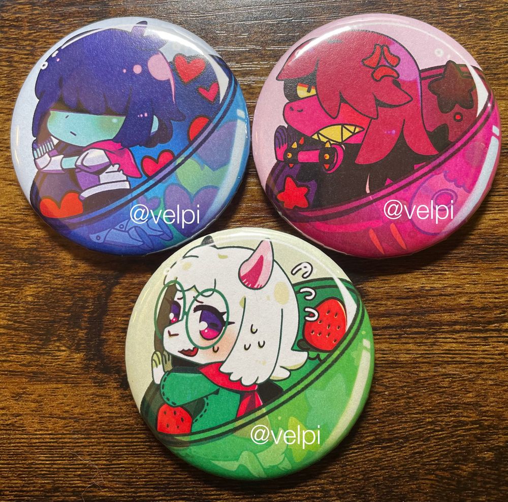 Kris, Susie, and Ralsei from Deltarune trapped inside of different colored gacha balls