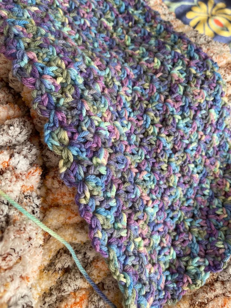 Crocheted scarf with multiple pastel colors. 