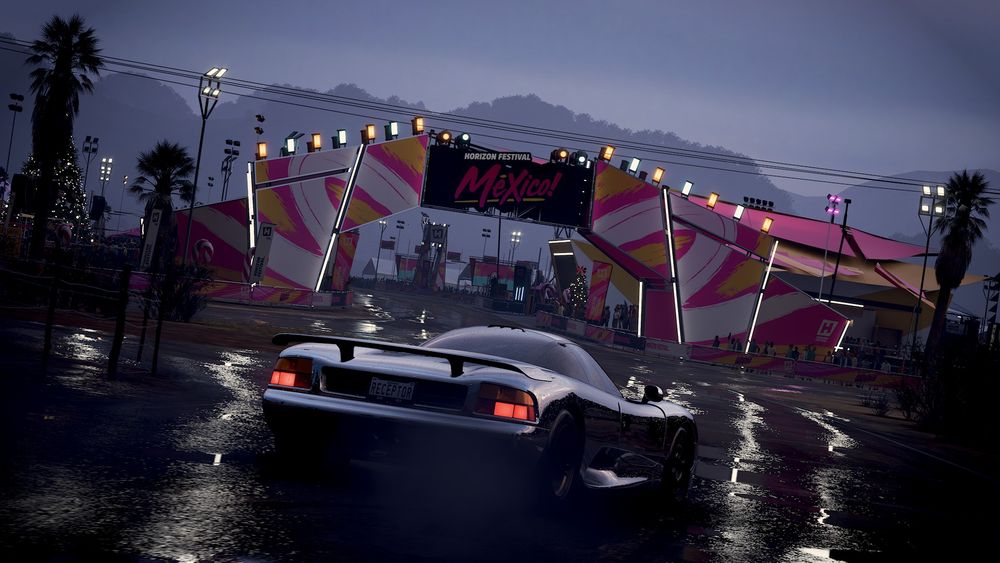 Photo of a retro supercar in silver approaching the entrance ti the Horizon festival at dusk, post rain.