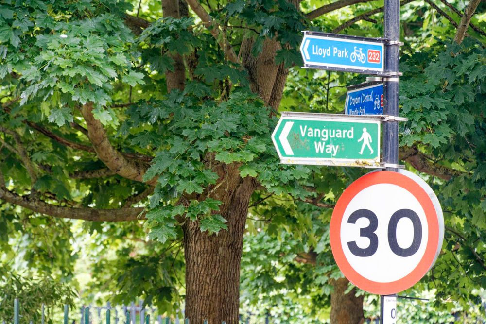 A black metal post has both a (30) sign, as well as a pointer to the Vanguard Way for walking, and cycling signs to Lloyd Park and Croydon.