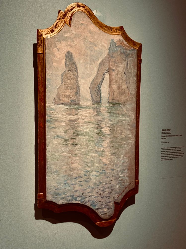 Étretat, L'Aiguille et la Porte d'Aval by Monet at the Art Gallery of Ontario. 

Cliff with an arch an a Needle rock with the sea painted in Monet’s Impressionistic style of concentrating on the light and the colour.

Not his first painting of the subject, but the only one on a wardrobe door from a local hotel. 

I expect he lost his security deposit