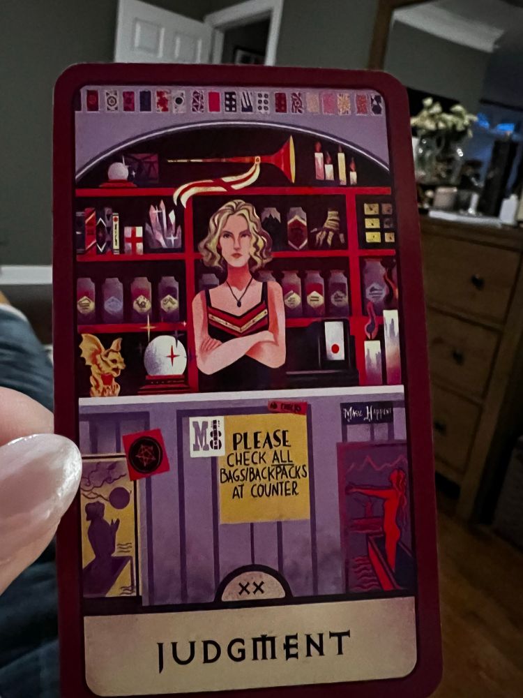 The Judgement Card of the Buffy the Vampire Slayer tarot deck features Anya behind the counter of the magic shop. 