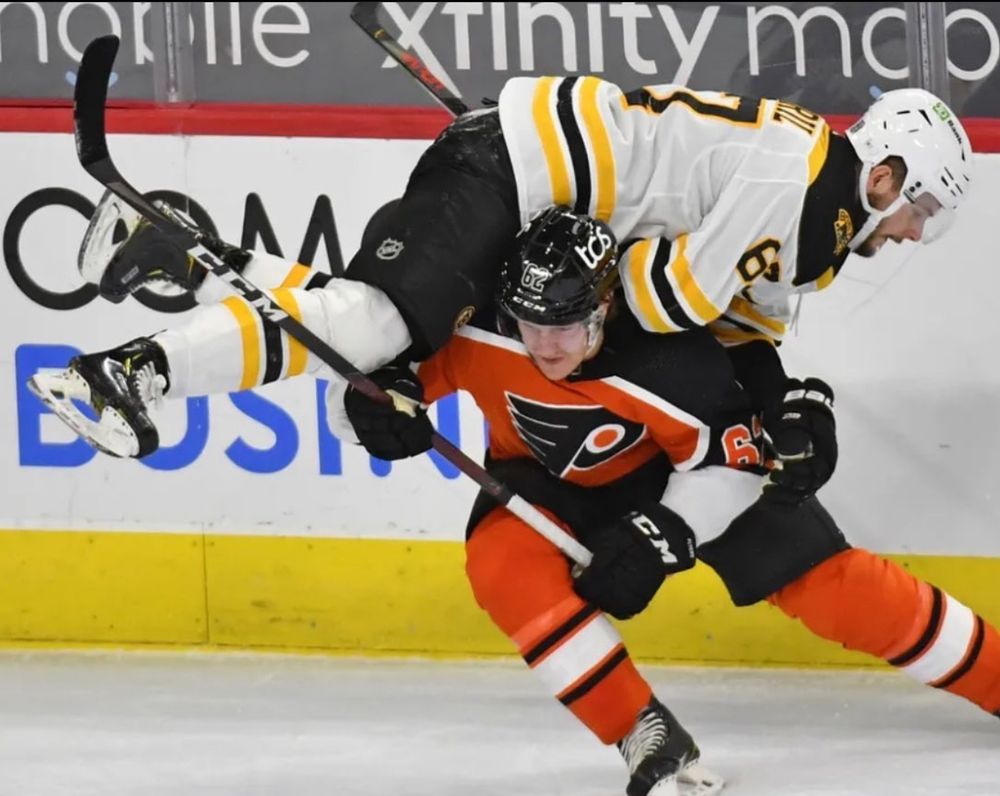 Flyers player carrying a Bruins player