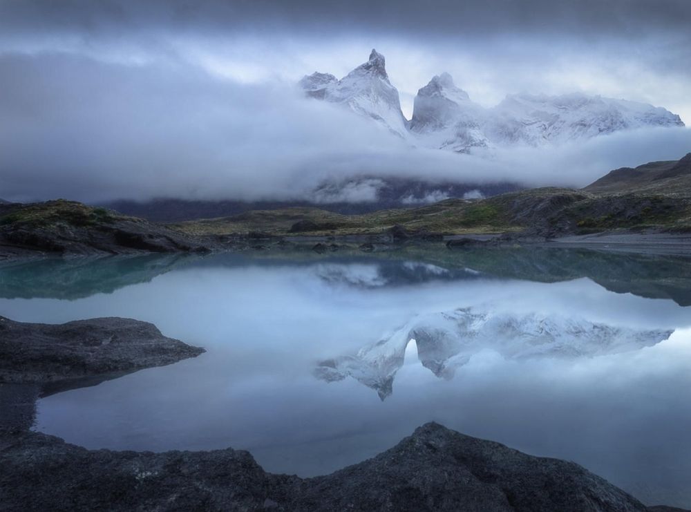 "This photo says a lot about Patagonian weather, which is absolutely unpredictable and very fast-changing. When I arrived at this location early in the morning, Cuernas, the mountains, were completely folded in mist. My friends and I were entertaining doing selfies and smartphone photos of each other, when all of a sudden the tops of the mountains cleared up. I had half of a minute to capture them before they were covered with thick mist again." - Oleg Rest, Great Outdoors photo contest winner

A landscape photographer from Prague, Oleg Rest started his work some years ago. His favorite locations are Czech Republic, Iceland, Norway, Patagonia, and Tuscany. He is an LucrOit filters brand ambassador.  
