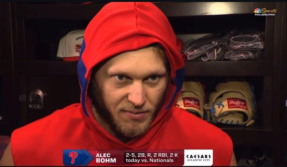 still of alec bohm from a postgame interview. he's stating intensely into the camera with his hood up, camera angle is low, he looks like a bridge troll