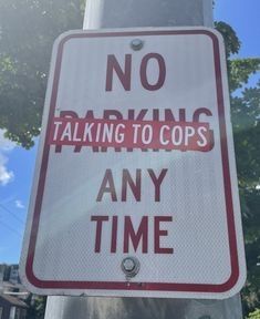 A photo of a rectangular white sign with red lettering. The sign says 
No Parking Any Time 
The word Parking has been covered by a wide red sticker with white lettering that says 
Talking To Cops
The sign now reads
No Talking To Cops Any Time