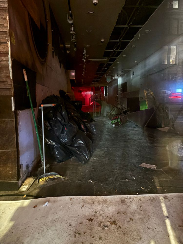 A long bare room, stripped of fixtures, the infamous back room visible