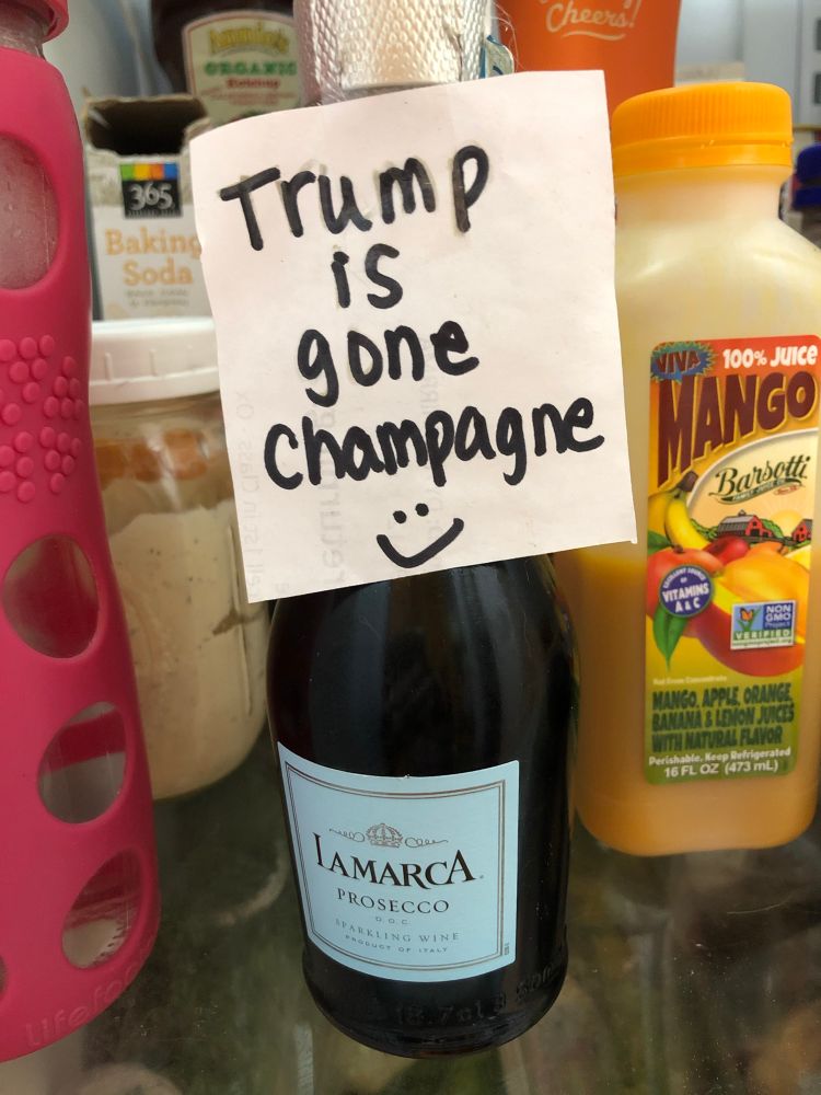 Bottle of champagne in the fridge with a post-it note that reads, “Trump is gone champagne :)”