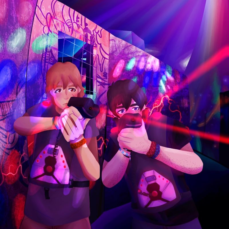 The background is of a laser tag arena in mostly purple tones with red, blue, and green lights scattered around. Matt and Keith are posed left of center, aiming their lasers to the right, offscreen. Both are wearing cord bracelets. Matt also has two rainbow bracelets, while Keith has a handmade trans pride bracelet.