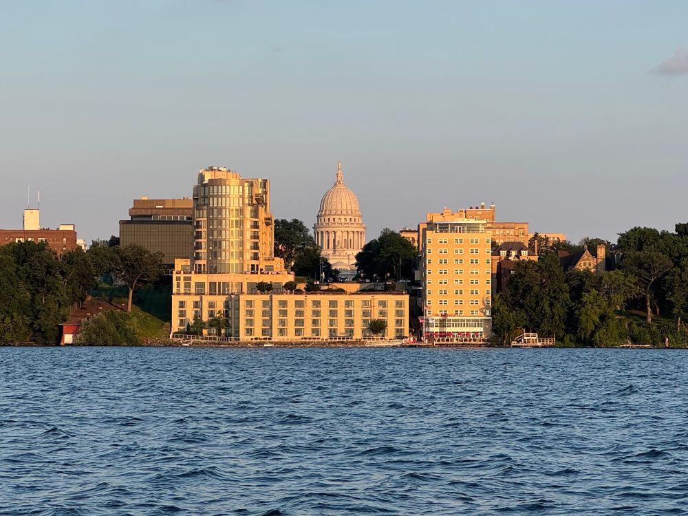 Photo of the Madison state capital peeking through the Edgewater hotel, from the water. 