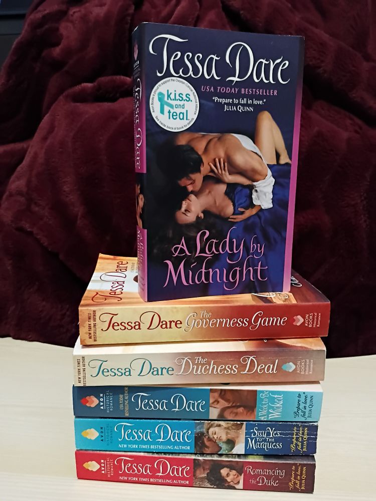 Six Tessa Dare books stacked on top of each other.