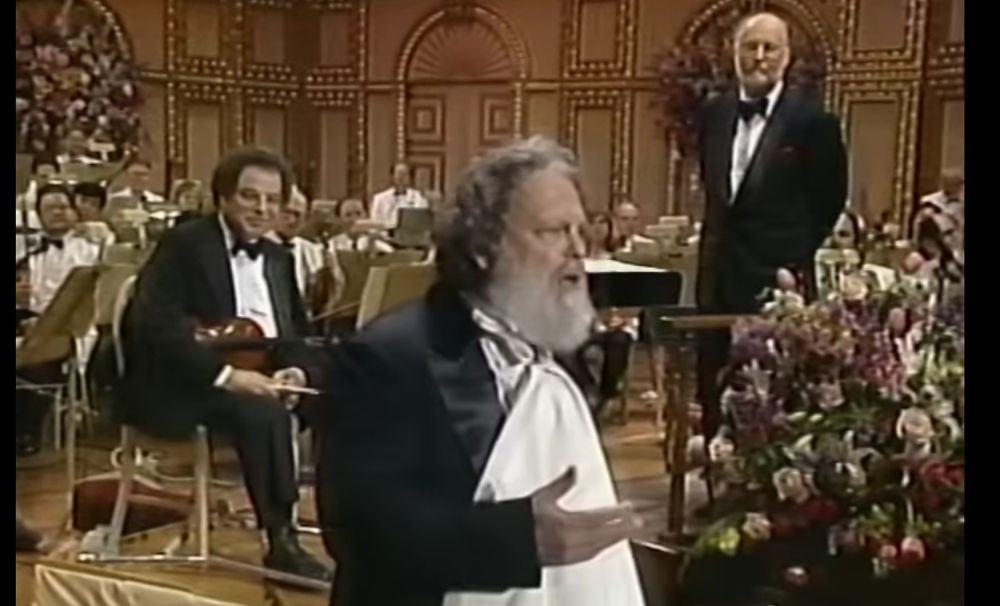 Picture of Itzhak Perlman, Peter Schikele aka P.D.Q Bach) and John Williams on stage, with an orchestra in the background.